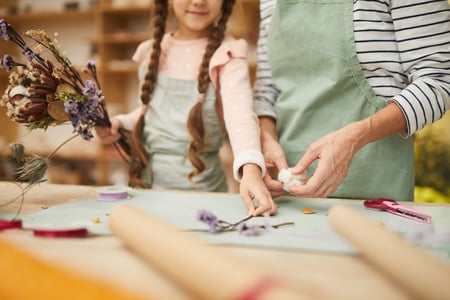 young girl creating art with flowers