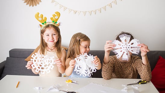 children makeing paper snowflakes